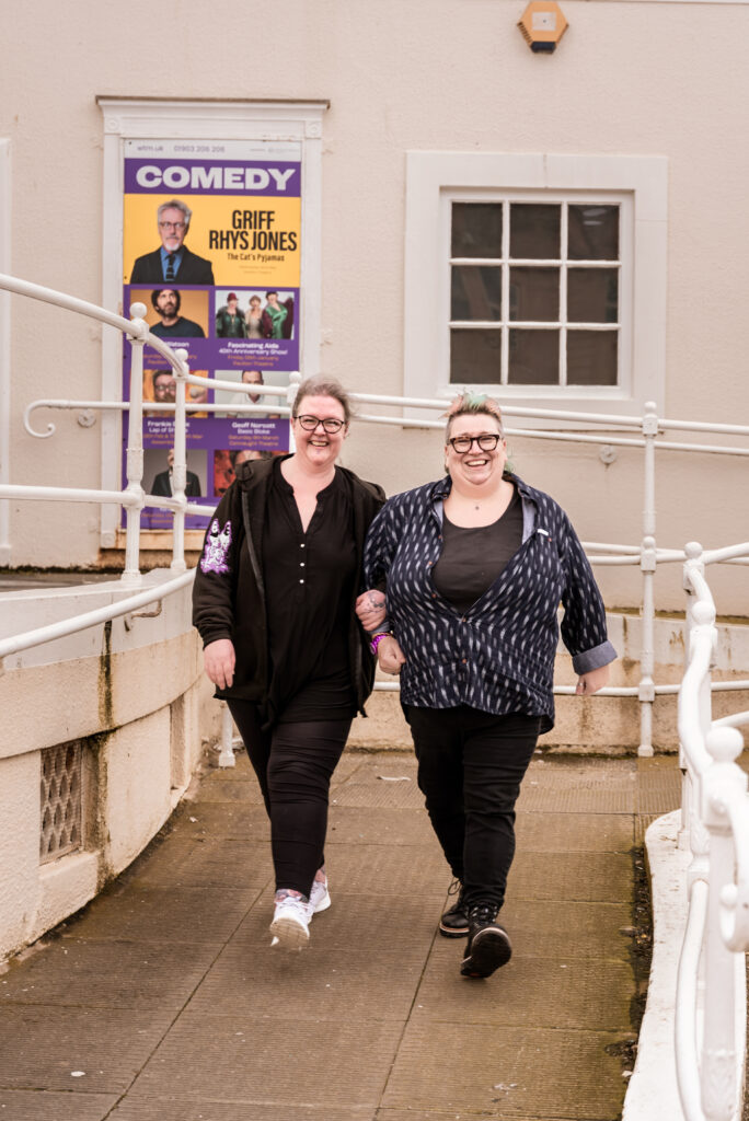 Two woman walking arm in arm