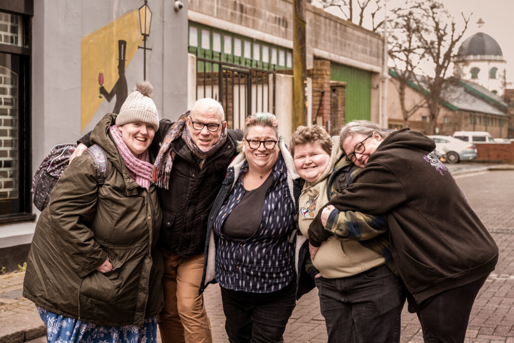 A group of people cuddling outside.