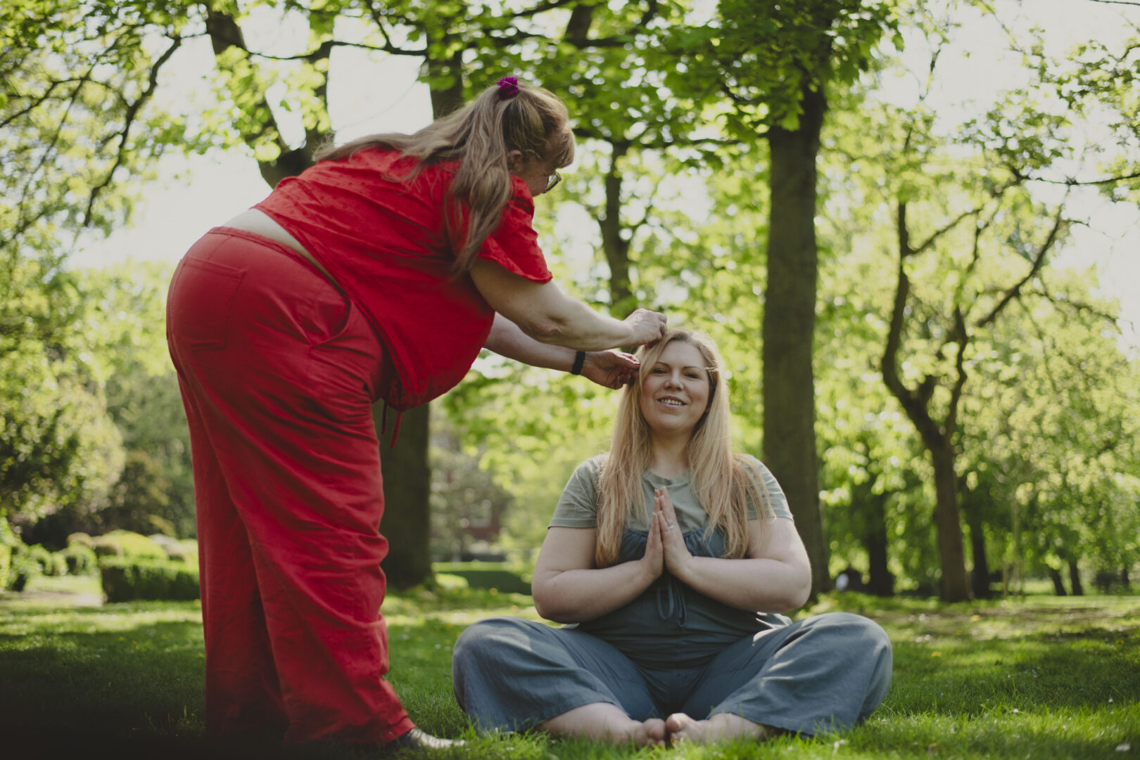 Female in red is fixing someone's hair. Image provided courtesy of Leeds Beckett University - leedsbeckett.ac.uk
